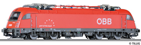 [Lokomotivy] → [Elektrické] → [BR 183] → 04965: elektrická lokomotiva červená s tmavě šedým šedým rámem a pojezdem a logem ÖBB